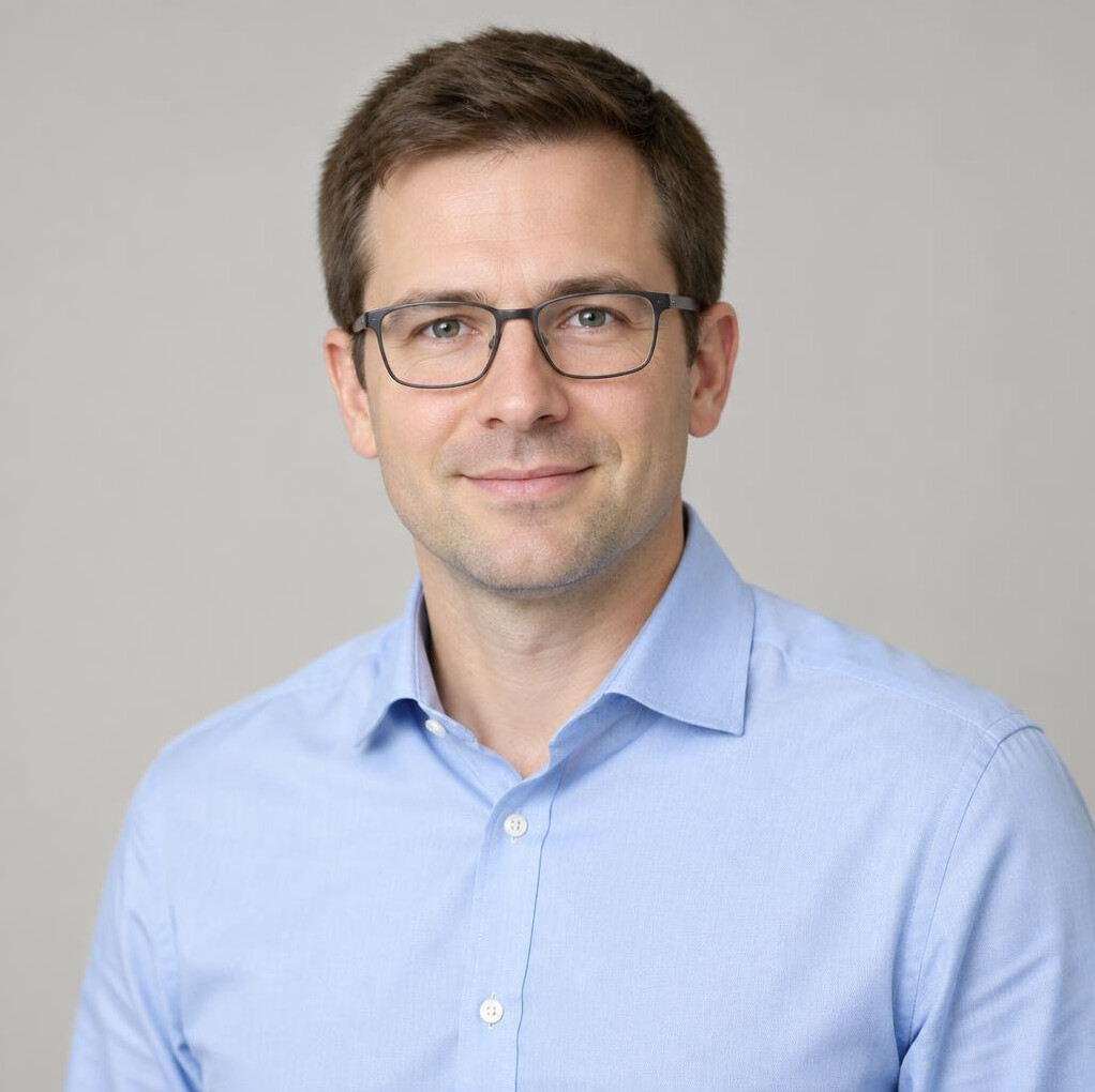 Portrait of a man with glasses and a light shirt